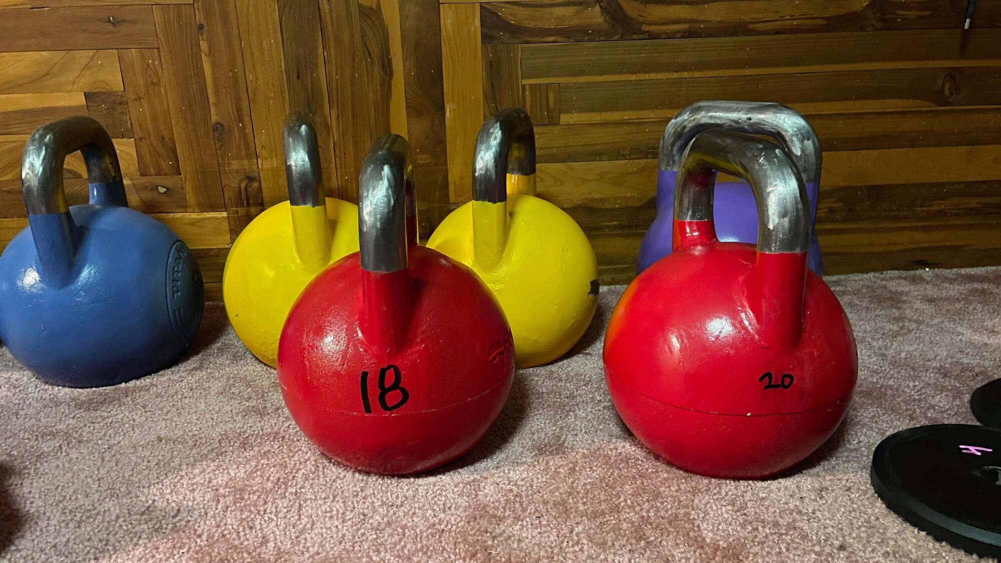 Two red adjustable kettlebells. One is labeled 18 and one is 20.