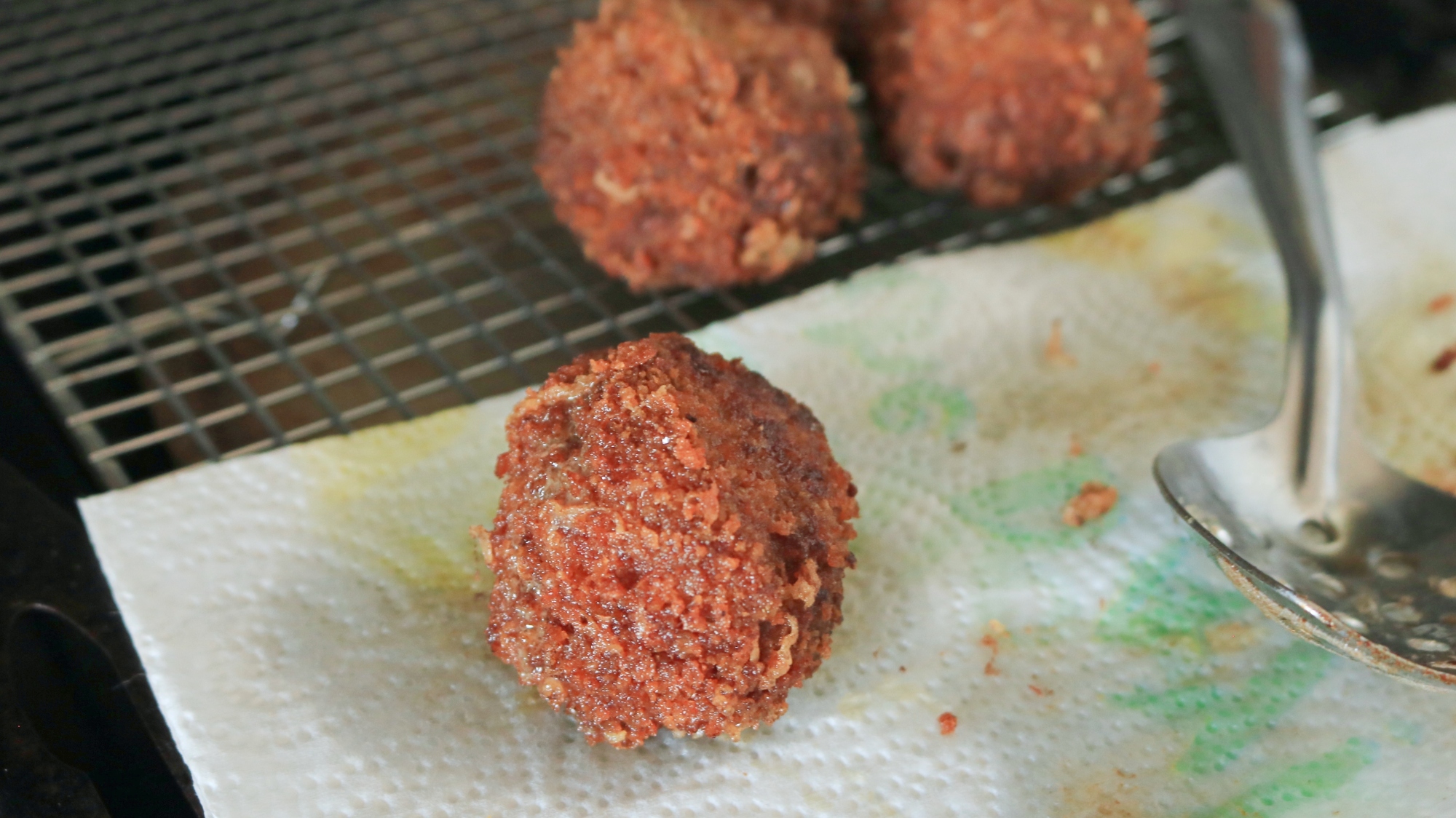 Fried meatball on a cooling rack.