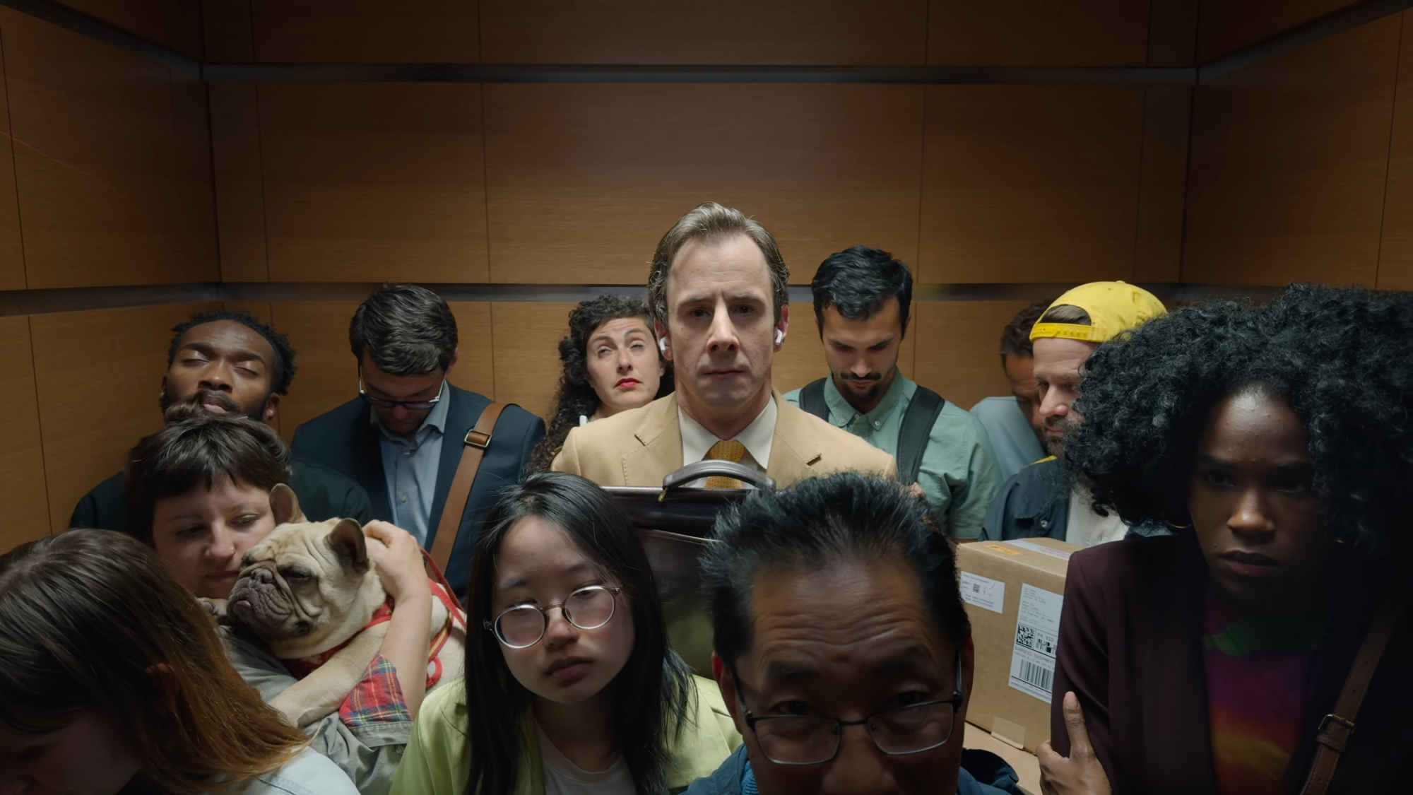 man wearing airpods in crowded elevator