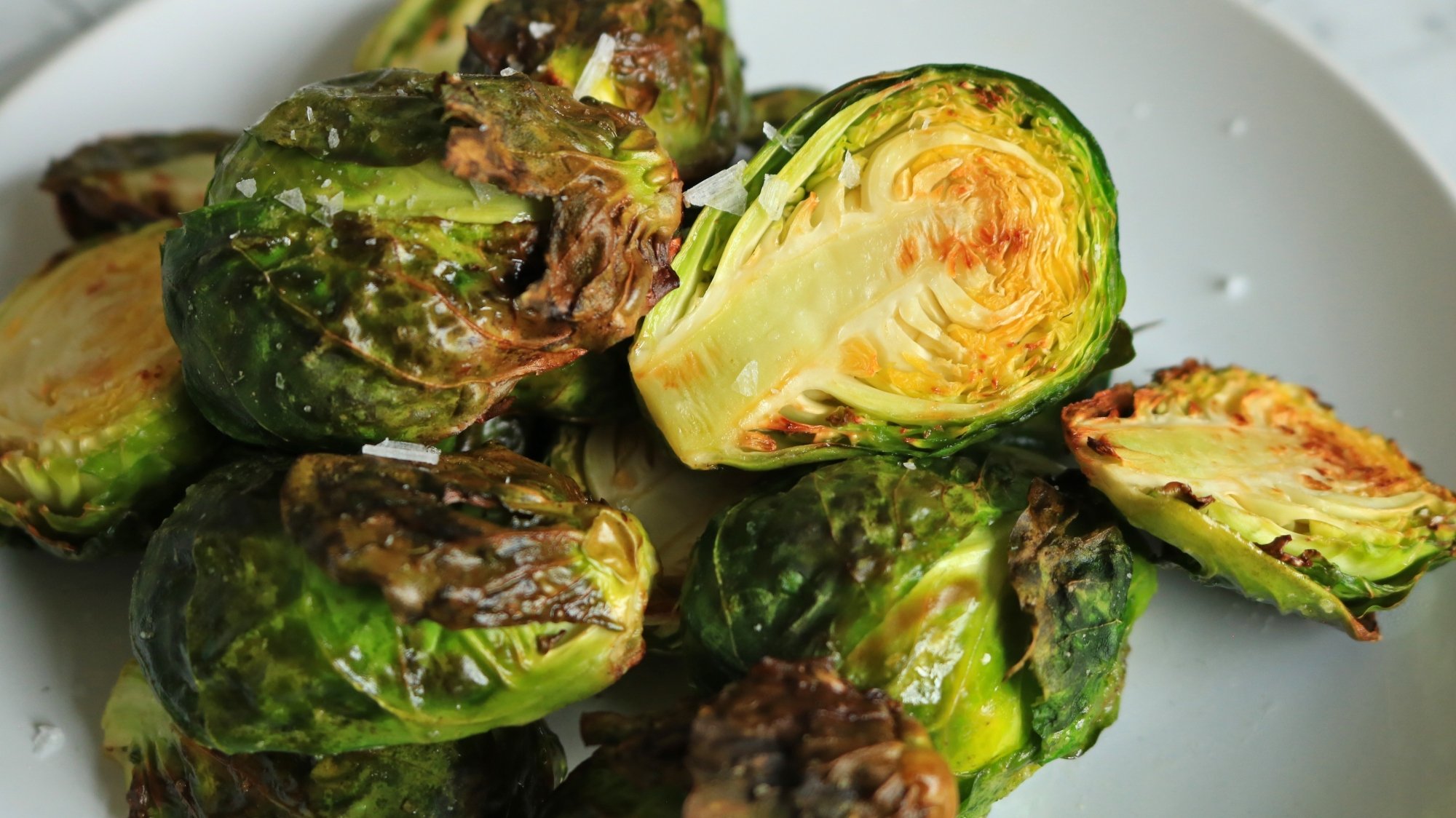 Split and roasted Brussels sprouts piled on a plate.