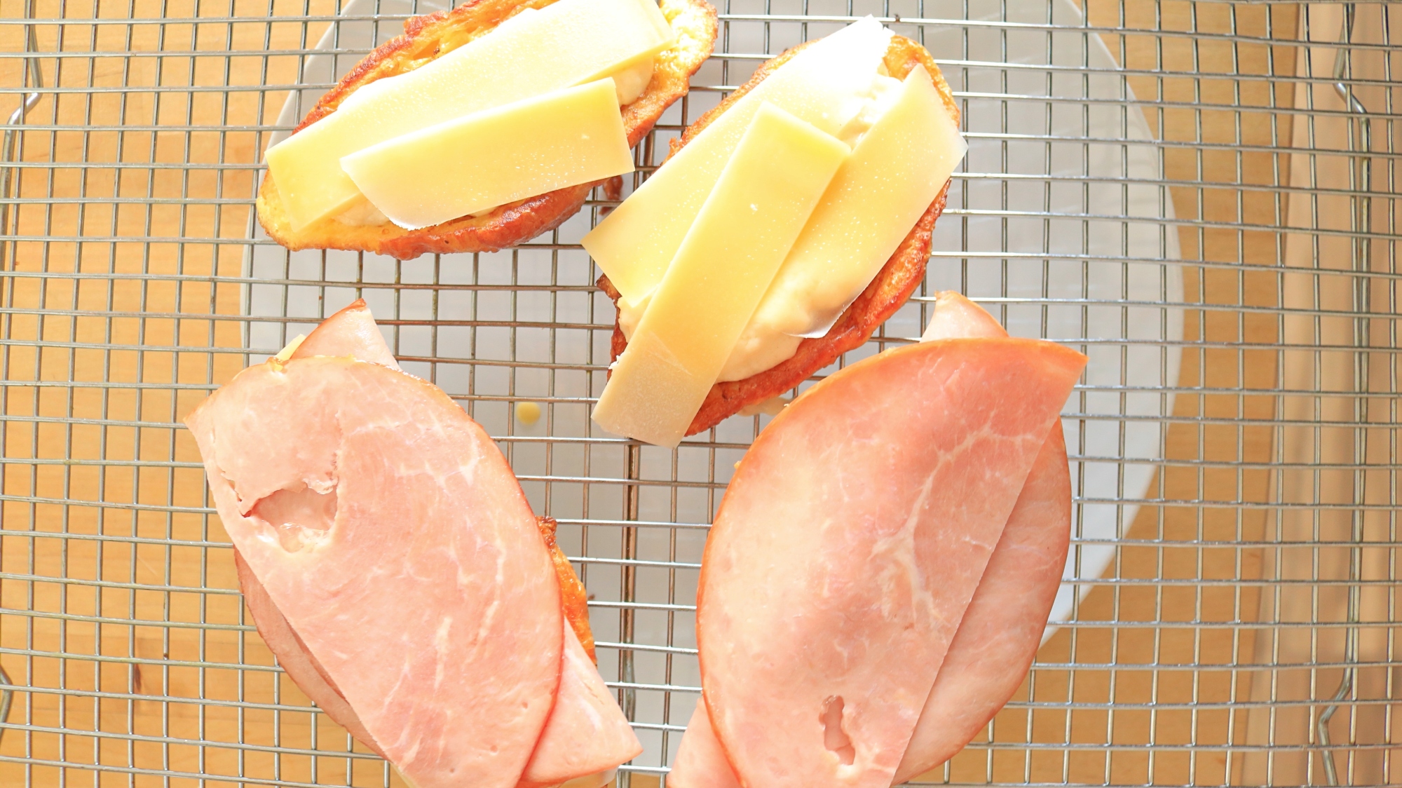 Sandwich being built with ham and cheese.